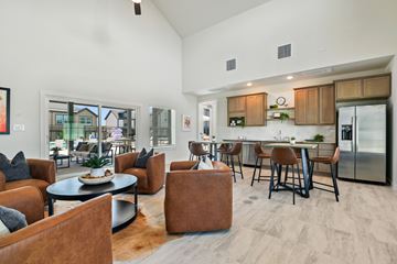 Grand Prairie apartment for rent - A modern living room with brown leather chairs and a black coffee table.