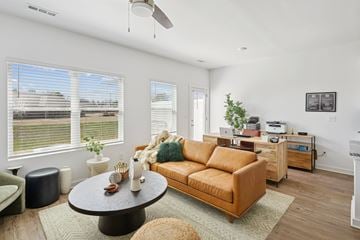 Huntsville apartment for rent - A living room with a brown couch and a round table.