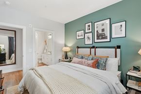 Suwanee apartment for rent - A bedroom with a large bed and pictures on the wall.