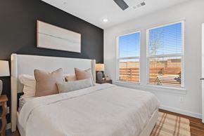 Grand Prairie apartment for rent - a bedroom with a large bed and hardwood floor and windows