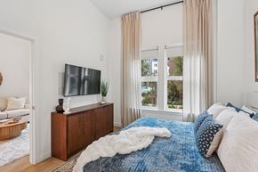 Huntsville apartment for rent - A bedroom with a large bed and a flat screen TV on a wooden stand.