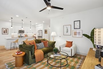 Lewisville apartment for rent - A living room with a green couch and a fan on the ceiling.