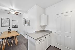 Littleton apartment for rent - A kitchen with white cabinets and a wooden table.