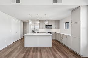 Fort Worth apartment for rent - A modern kitchen with white cabinets and a wooden floor.