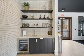 Hoschton apartment for rent - a kitchen with black cabinets and a white brick wall