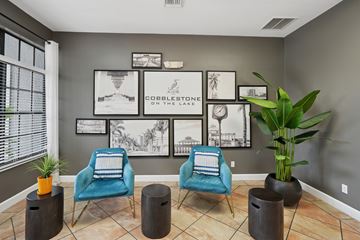 Ft. Myers apartment for rent - A living room with a blue chair and a plant.