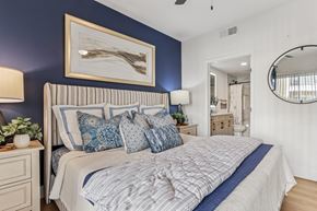 The Colony apartment for rent - A bedroom with a large bed and a painting above it.