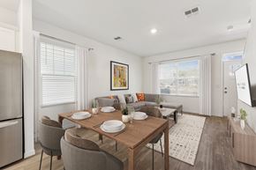 Gainesville apartment for rent - A dining room with a table set for two and a couch with a pillow.