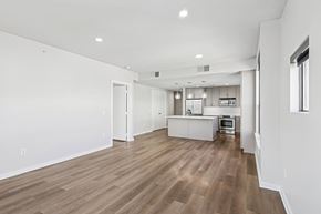 Fort Worth apartment for rent - A spacious room with wooden flooring and white walls.