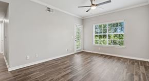 Grand Prairie apartment for rent - A room with a ceiling fan and a window with a view of trees.