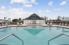 Pooler apartment for rent - A large swimming pool with a building in the background.