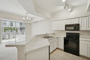 Ft. Myers apartment for rent - A kitchen with white cabinets and a black oven.