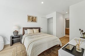 Bethesda apartment for rent - A bedroom with a large bed and a nightstand with a lamp.