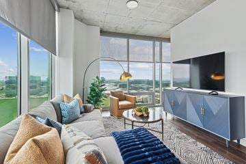 Frisco apartment for rent - A modern living room with a grey sofa and a blue sideboard.