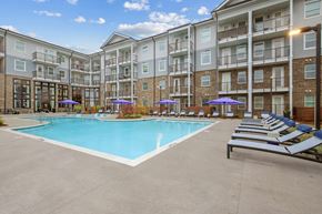 Acworth apartment for rent - an apartment building with a swimming pool and lounge chairs