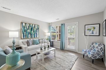 Cary apartment for rent - A living room with a white couch, a coffee table, and a painting on the wall.