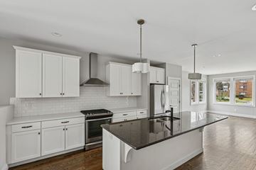 Nashville apartment for rent - A modern kitchen with white cabinets and a black countertop.