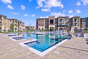 Prosper apartment for rent - A swimming pool surrounded by apartment buildings on a sunny day.