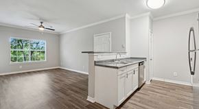 Grand Prairie apartment for rent - A kitchen with white cabinets and a wooden floor.