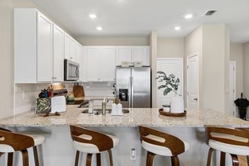 Jacksonville apartment for rent - A kitchen with white cabinets and a granite countertop.