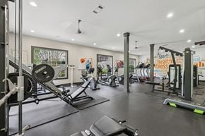 Atlanta apartment for rent - A gym with a variety of equipment including a weight bench, a rowing machine, and a treadmill.