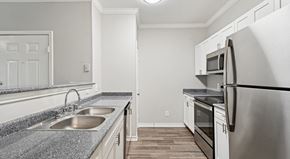 Grand Prairie apartment for rent - A kitchen with a sink, refrigerator, and oven.