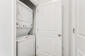 Gainesville apartment for rent - A white washing machine and dryer are in a small space between a door and a wall.