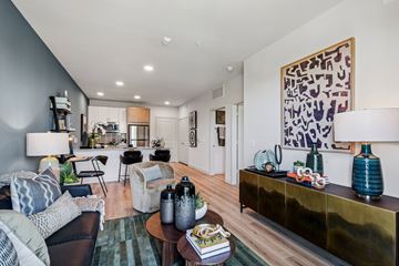 Cedar Park apartment for rent - A living room with a black couch and a gold sideboard.