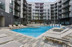 Huntsville apartment for rent - A large swimming pool surrounded by sun loungers in a courtyard of apartment buildings.