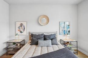 Austin apartment for rent - A bedroom with a large bed and two small tables with decorations on them.