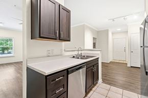 Grand Prairie apartment for rent - A kitchen with dark brown cabinets and a white countertop.