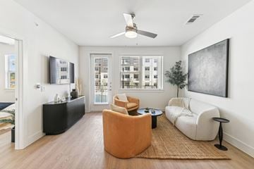 San Antonio apartment for rent - A living room with a brown rug and a ceiling fan.