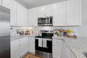 Jacksonville apartment for rent - A kitchen with white cabinets and a stainless steel refrigerator.
