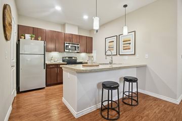 Mckinney apartment for rent - A kitchen with a white island and two black stools.