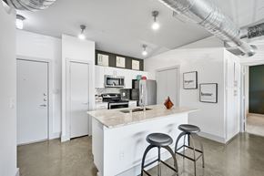 Dallas apartment for rent - a kitchen with a bar and stools in front of a counter top