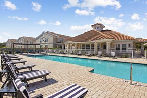 Estero apartment for rent - A pool with sun loungers and a building in the background.