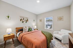 Jacksonville apartment for rent - A bedroom with a bed, a nightstand, a chair, and a window.