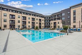 Suwanee apartment for rent - A large swimming pool is surrounded by apartment buildings.