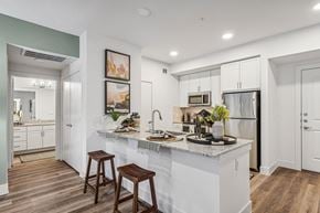 Mckinney apartment for rent - an open kitchen with a large island with stools