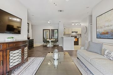 Tampa apartment for rent - A modern living room with a white sofa and a wooden cabinet.