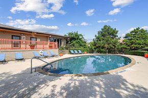 Dallas apartment for rent - A small pool with a metal railing and a few chairs.