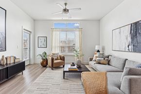Atlanta apartment for rent - A living room with a grey couch, a brown armchair, a coffee table, and a ceiling fan.