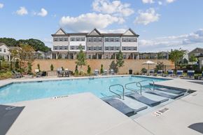Dacula apartment for rent - A large swimming pool in front of a multi-story building.