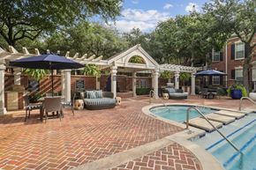 Dallas apartment for rent - A pool area with a brick patio and a small pool.