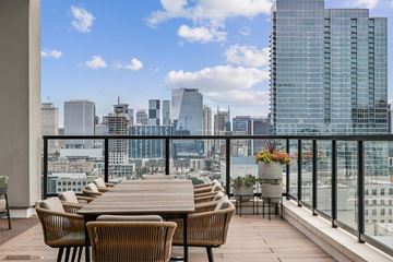 Nashville apartment for rent - A balcony with a table and chairs overlooking a city skyline.