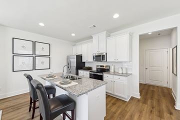 Lagrange apartment for rent - A kitchen with white cabinets and a granite countertop.