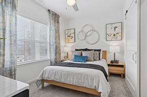 Forney apartment for rent - A bedroom with a large bed and a ceiling fan.