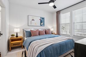 Frisco apartment for rent - A bedroom with a bed, a nightstand, and a ceiling fan.