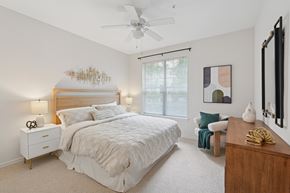 Raleigh apartment for rent - A bedroom with a large bed and a ceiling fan.