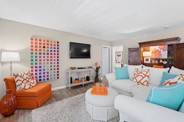 Winston Salem apartment for rent - A living room with a white couch and orange accents.